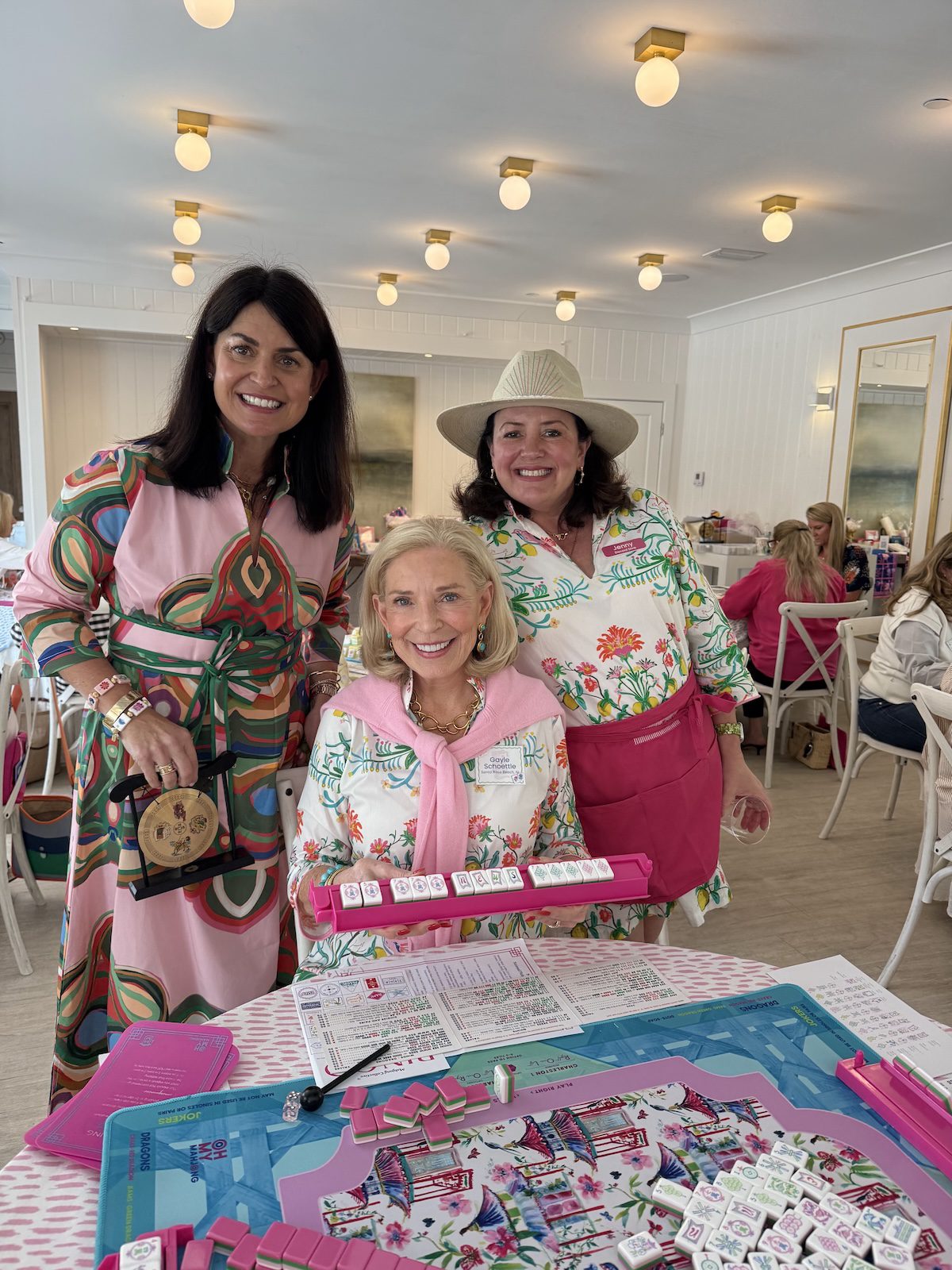 lynn and helper with a lady playing mahjong holding up a rack showing she won